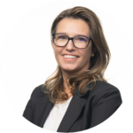 Makler Jelena-Pirker mit schulterlangem, gewelltem Haar trägt weißen Pullover und schwarzen Blazer vor weißem Hintergrund in runder Bildkomposition